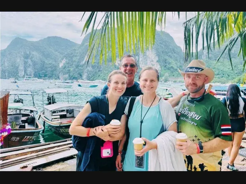 Discover Church tour group at a tropical Thai harbor with long-tail boats and limestone cliffs during the Thailand pilgrimage
