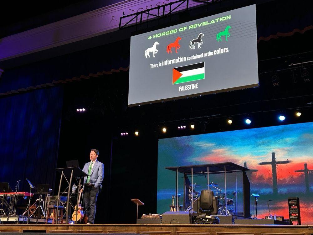 Pastor Steve Cioccolanti speaking at Evangel Temple Church in Mississippi with a large screen display