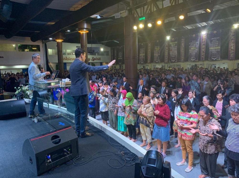Pastor Steve Cioccolanti leading a prayer line and altar call in Semarang, Indonesia with congregation receiving prayer