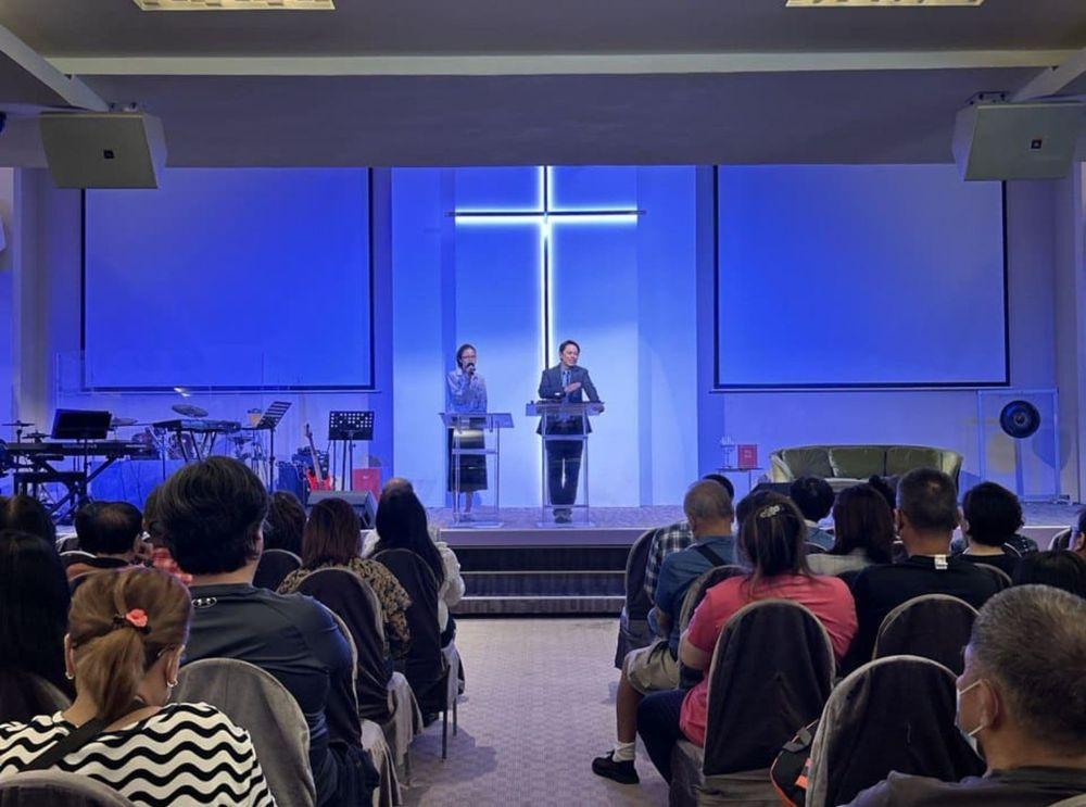 Pastor Steve Cioccolanti at a Chinese church service in Malaysia with cross and worship band