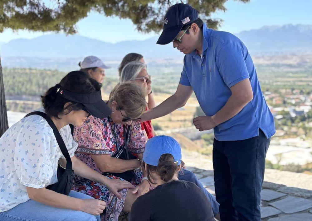 Pastor Steve Cioccolanti leading a tour group in prayer on a hilltop overlooking a valley in Turkey